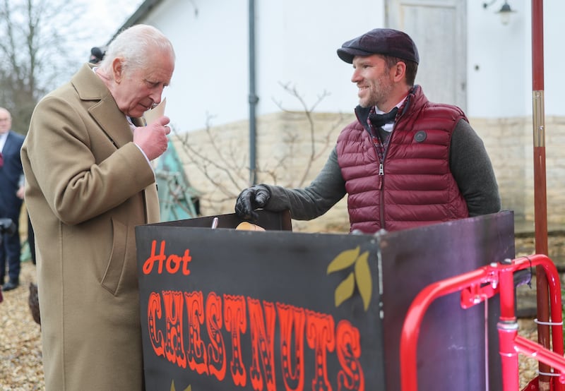 The King smells the roasted chestnuts handed to him by vendor Paul Venn