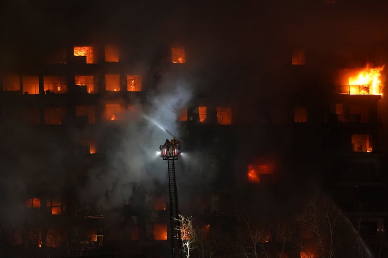 Firefighters work as a housing block burns in Valencia, Spain (Alberto Saiz/AP)