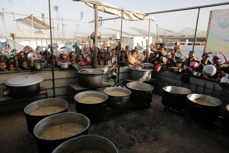 Palestinians collect food aid in Khan Younis, Gaza Strip (Jehad Alshrafi/AP)