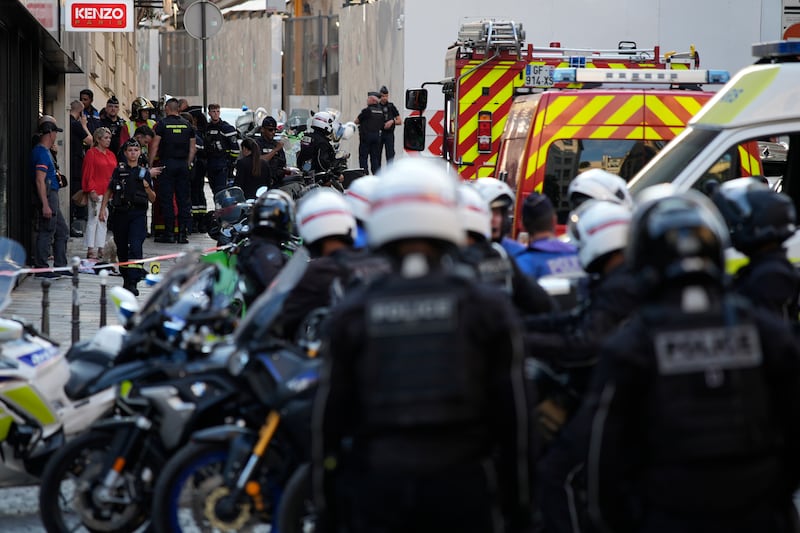 Police officers and rescue workers gather near the Champs-Elysees (David Goldman/AP)