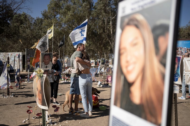 A family visits the the memorial marker of their loved one, Bar Lior Nakmuli, at the site of the Nova music festival, where hundreds of revellers were killed or kidnapped by Hamas (Maya Alleruzzo/AP)