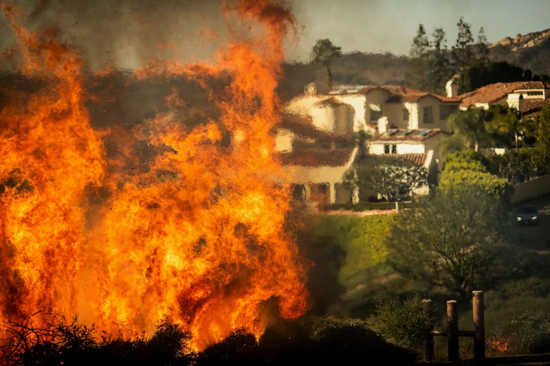 Flames rise as the Palisades Fire advances on homes in the Pacific Palisades neighbourhood of Los Angeles (Ethan Swope/AP)