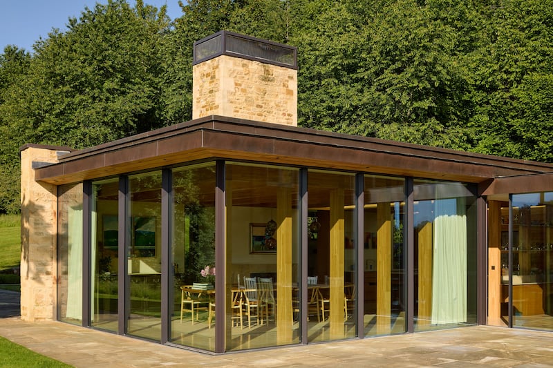 Timber and glass frame extension with floor to ceiling sliding doors – a light-filled, modern dining and entertaining space that blends in naturally to the landscape.