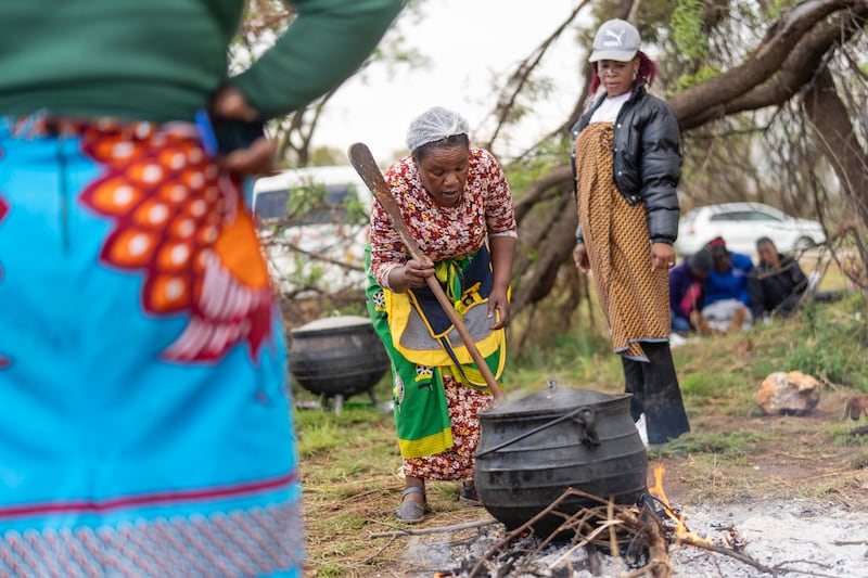 Relatives of miners and community members wait near the shaft of a closed mine where illegal miners are inside in Stilfontein, South Africa (Jerome Delay/AP)