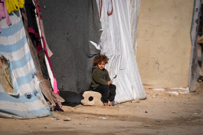 A child sits outside a tent at a camp for displaced Palestinians in Deir al-Balah, central Gaza Strip (Abdel Kareem Hana/AP)