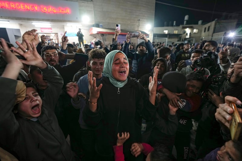 Palestinians celebrate the announcement of a ceasefire deal between Hamas and Israel in Deir al-Balah, central Gaza (Abdel Kareem Hana/AP)