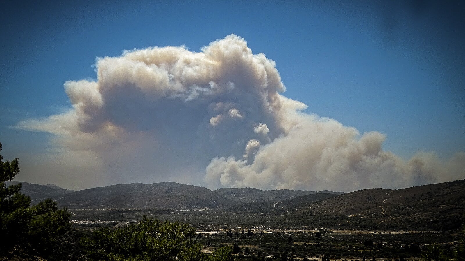 A cloud of smoke from a forest fire rises over Rhodes (Argyris Mantikos/Eurokinissi/AP)