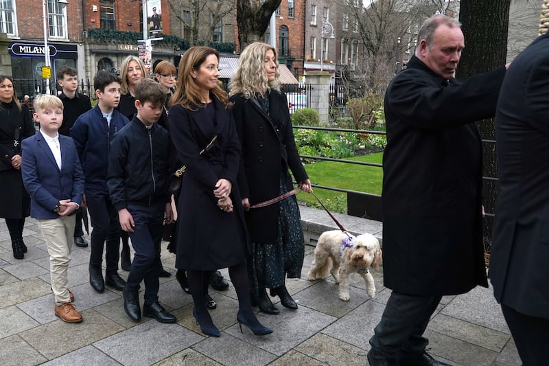 Charlie Bird’s wife Claire and his dog Tiger follow his coffin as it arrives for a service at Mansion House in Dublin