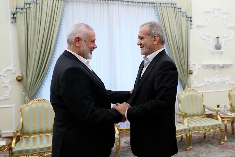 In this photo released by the Iranian Presidency Office, president Masoud Pezeshkian, right, shakes hands with Hamas chief Ismail Haniyeh (Iranian Presidency Office via AP)