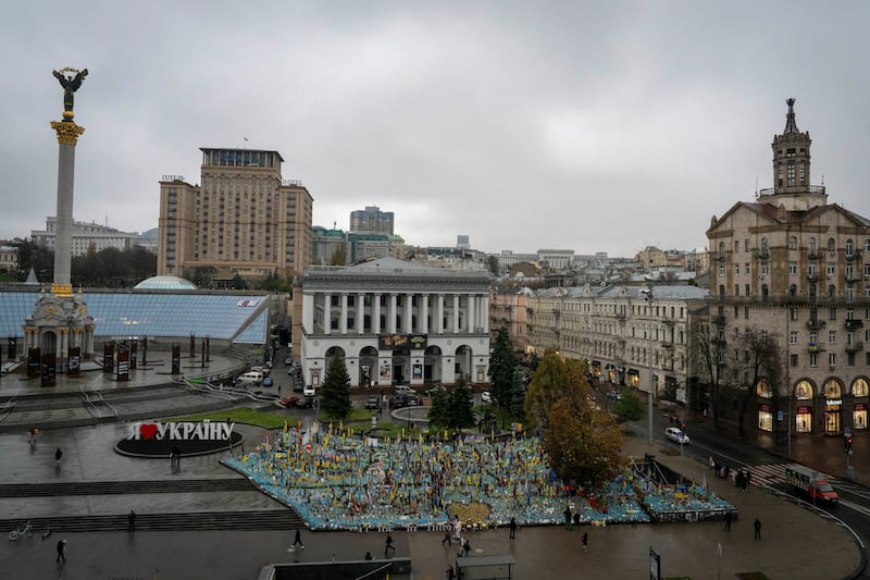 People walk past the memorial to fallen soldiers in Independence Square in Kyiv, Ukraine (Efrem Lukatsky/AP)