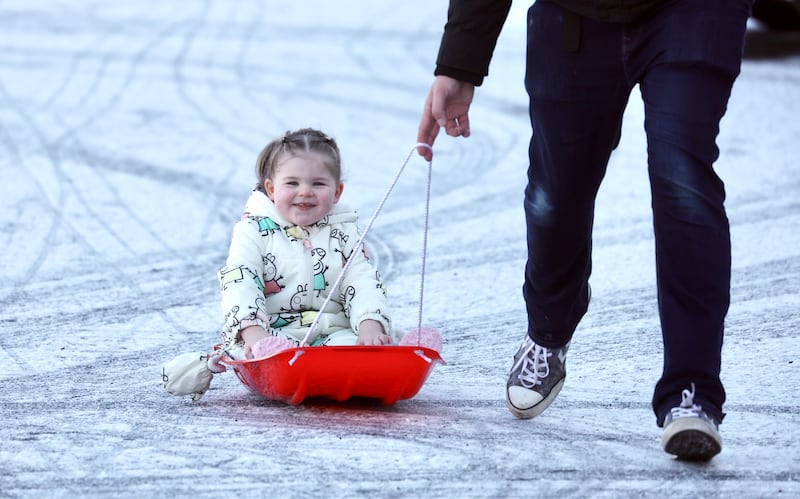 Danny MacGinty  pulls his daughter Amber along in her sled through Sion Mills in Co Tyrone during a frosty day. PICTURE: COLM LENAGHAN Weather Snow FRost