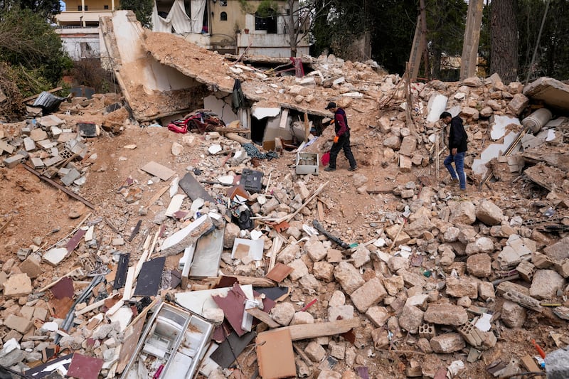 Displaced residents walk on the rubble of their destroyed house in Baalbek, eastern Lebanon (Hassan Ammar/AP)