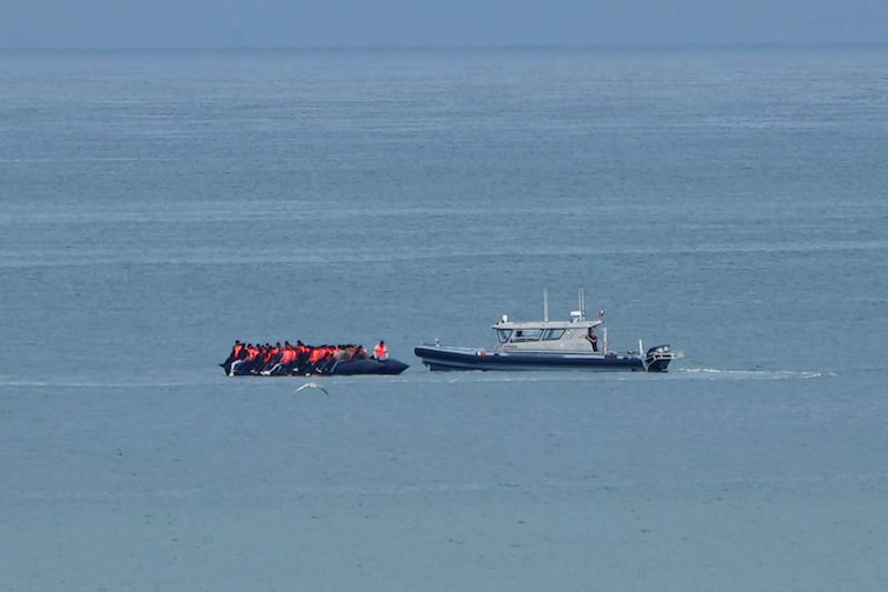 A boat thought to carry migrants is escorted by a vessel from the French Gendarmerie Nationale in the English Channel (Nicolas Garriga/AP)