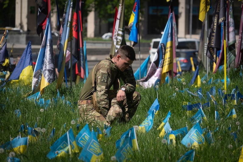 A Ukrainian soldier plants a small national flag on a grassed area in Independence Square (Efrem Lukatsky/AP)