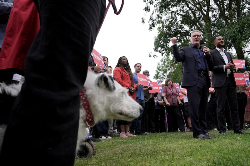 Labour leader Sir Keir Starmer gives a speech during a visit to the Shoulder of Mutton Pub in Little Horwood, Buckinghamshire, while a dog watches on