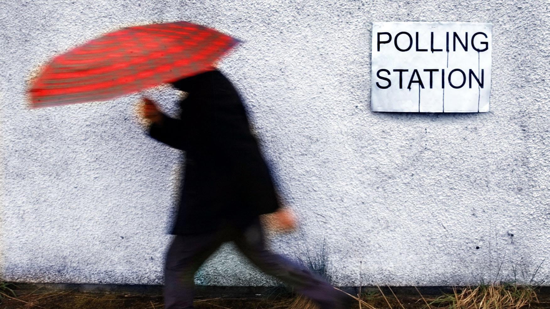 A man makes his way to a polling station in the rain