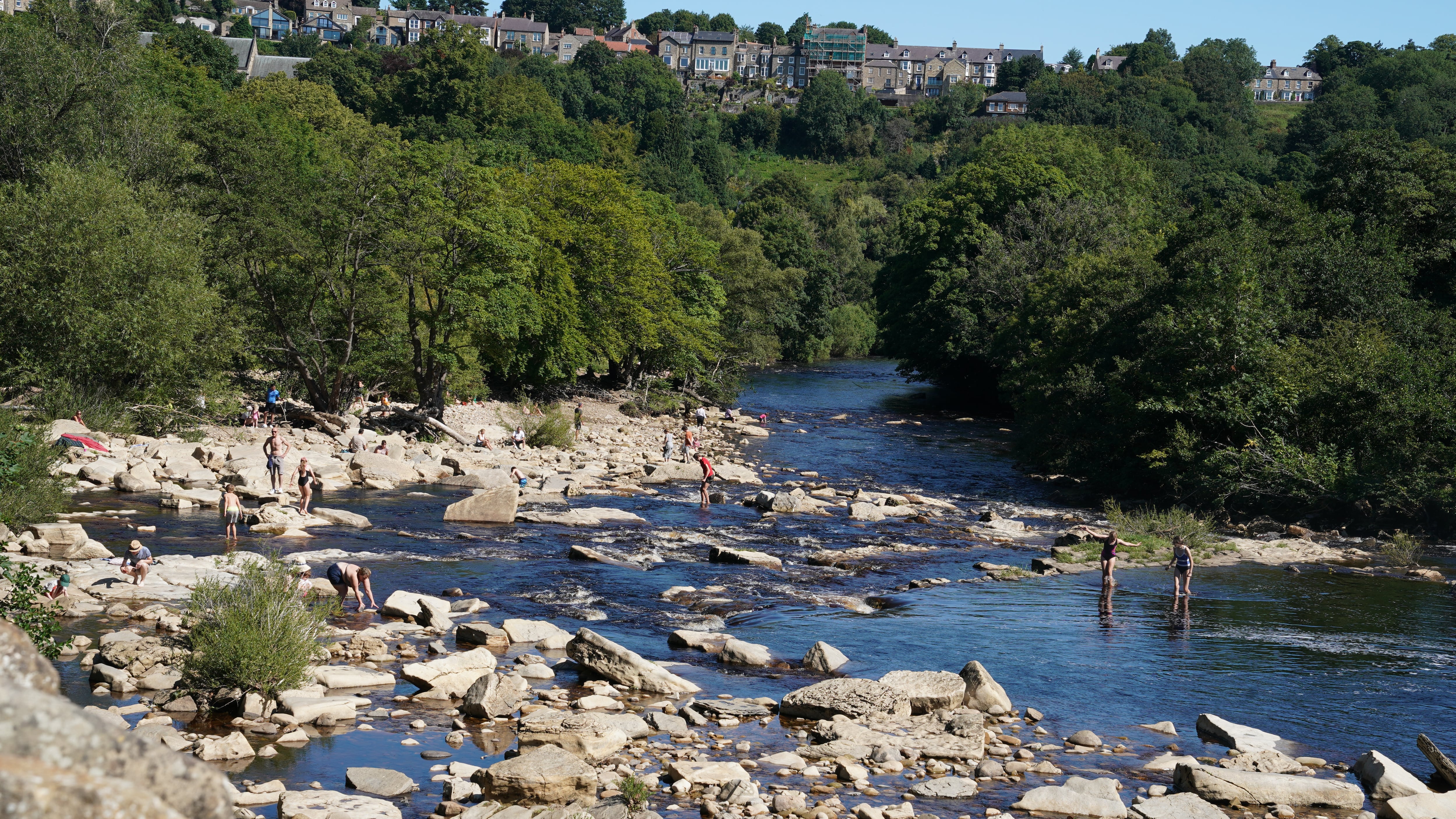 People enjoy hot weather at Richmond Falls on the River Swale, North Yorkshire
