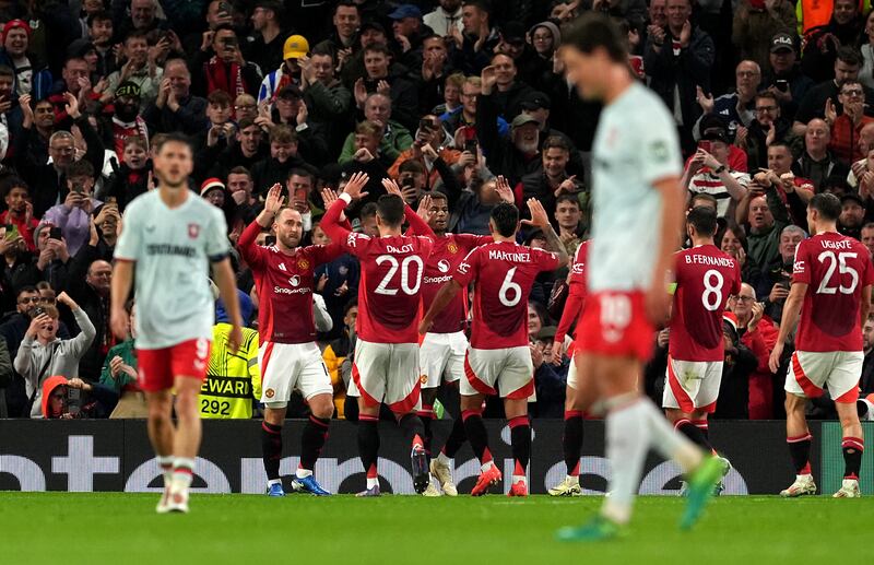 Manchester United’s players celebrate with Christian Eriksen, second left, after he opened the scoring