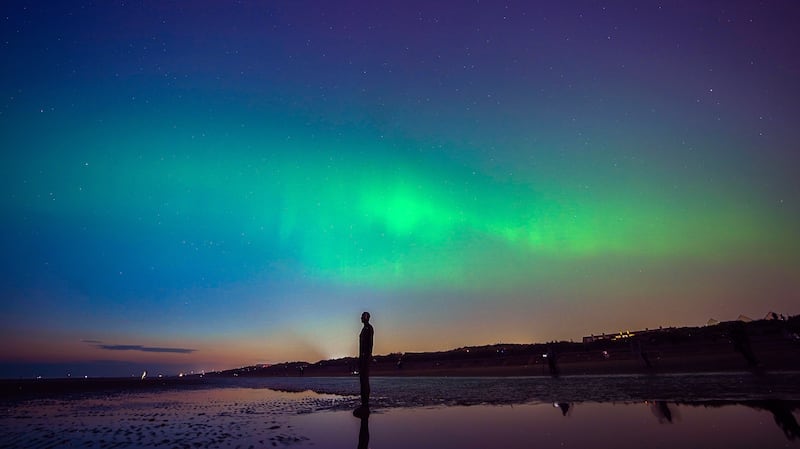 The lights glow on the horizon at Another Place by Anthony Gormley, Crosby Beach, Liverpool , Merseyside