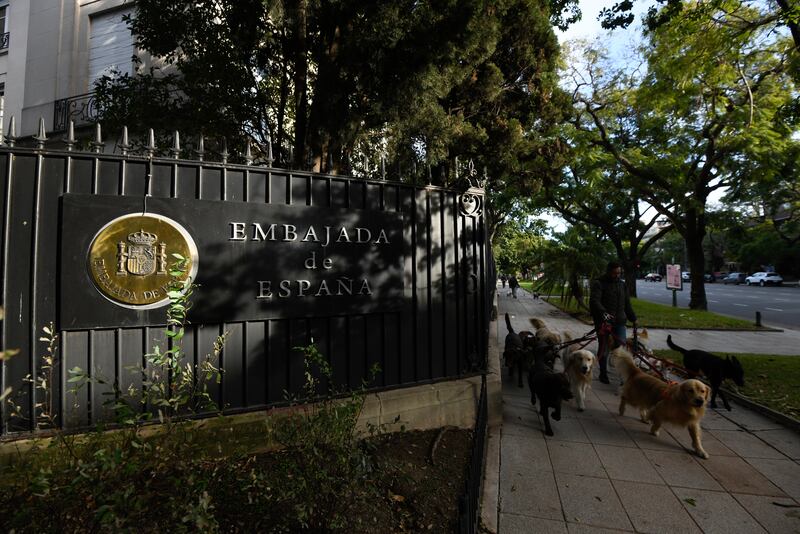 A man walks dogs past Spain’s embassy in the Palermo neighbourhood of Buenos Aires, Argentina (Gustavo Garello/AP)