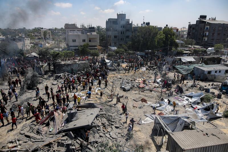 Palestinians inspect the damage at a site hit by an Israeli bombardment on Khan Younis (Jehad Alshrafi/AP)