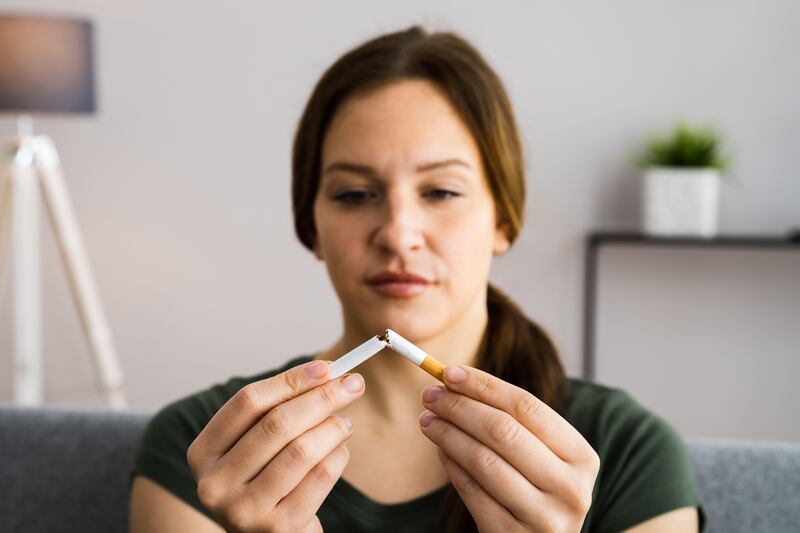 Woman breaking a cigarette in half