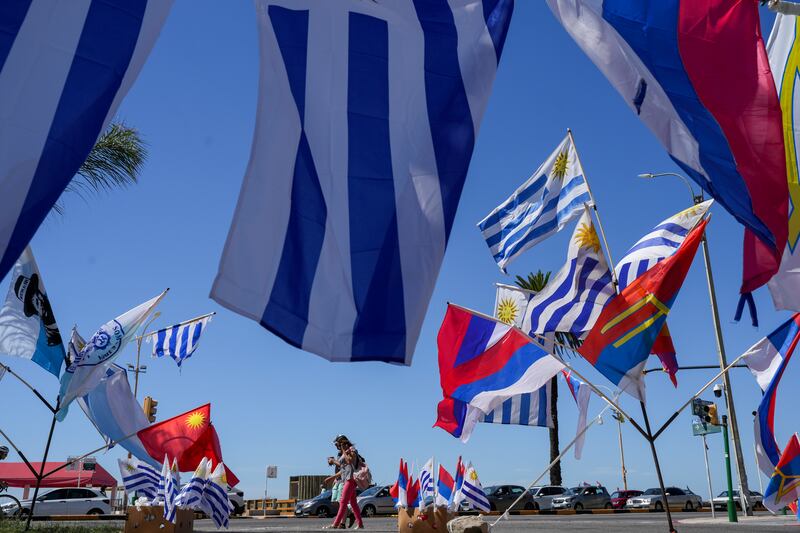 Uruguay’s national flag and political party banners fly under a blue sky on election day in Montevideo (Natacha Pisarenko/AP)