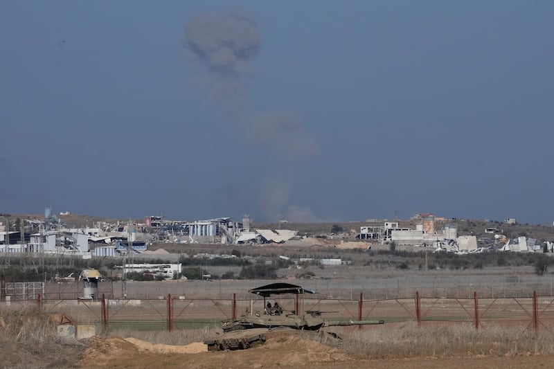 An Israeli tank sits on the Israeli-Gaza border, with a cloud of smoke inside the Gaza Strip in the background (Matias Delacroix/AP)