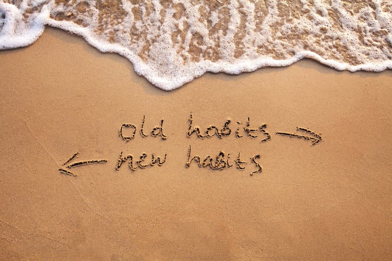 Old habits vs new habits written in the sand