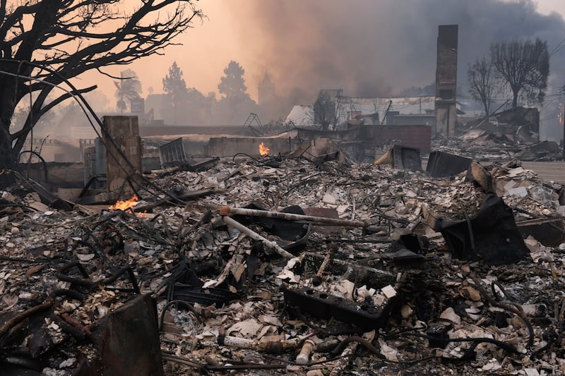 The Palisades Fire ravages a neighbourhood amid high winds in the Pacific Palisades neighbourhood of Los Angeles (Damian Dovarganes/AP)