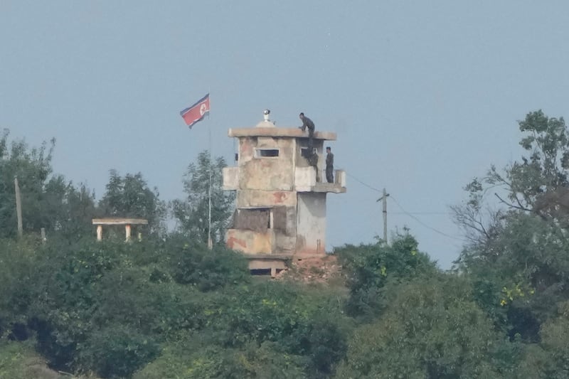 North Korean soldiers work at the North’s military guard post as a North Korean flag flutters in the wind, seen from Paju, South Korea (Ahn Young-joon/AP)