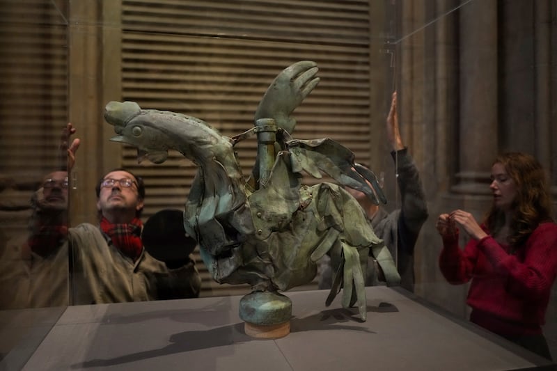 Technicians place a glass panel around the rooster while it is on display in Paris (AP Photo/Thibault Camus)