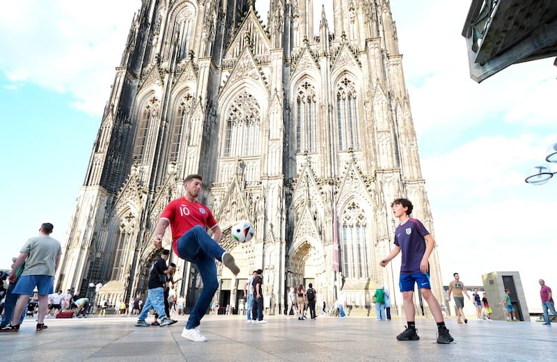 England fans play football in front of Cologne Cathedral ahead of Tuesday’s game