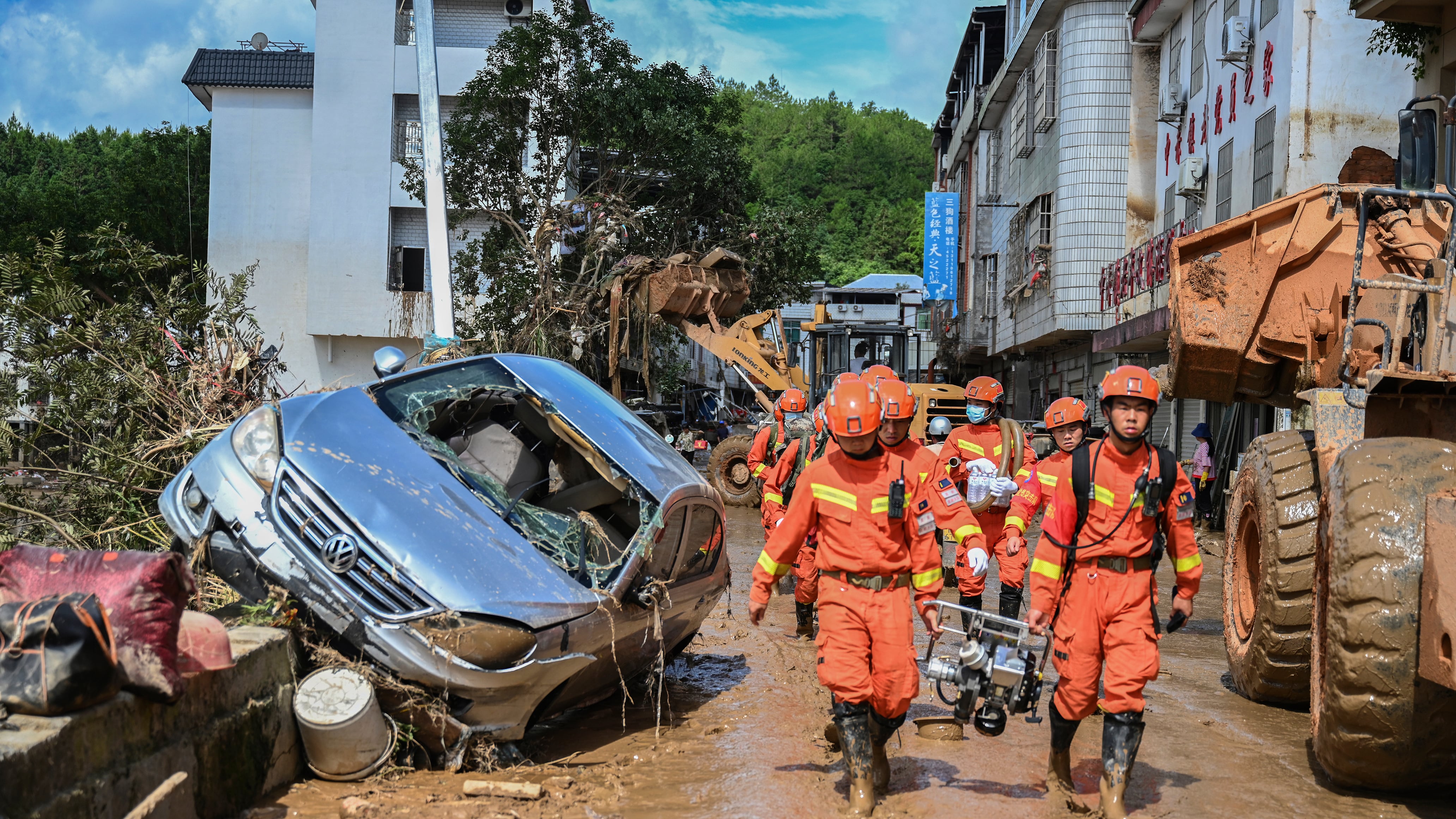 Rescuers carrying equipment enter a flood-affected area in Wuping County of Longyan City, in south-east China’s Fujian Province (Zhou Yi/Xinhua via AP)