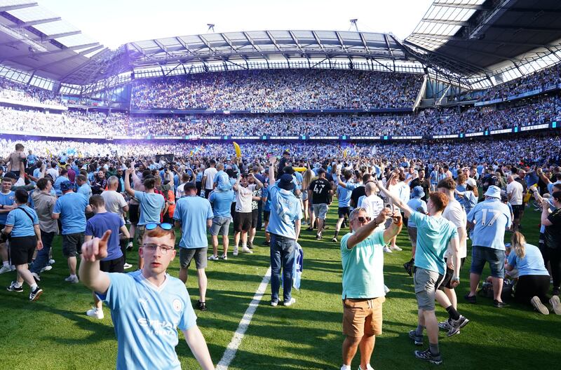 Manchester City fans invade the pitch following their title success