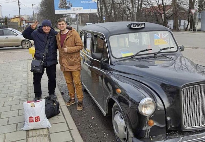 Roman Tymchyshyn (right) with a Ukrainian passenger who he drove in his black cab to the Polish border