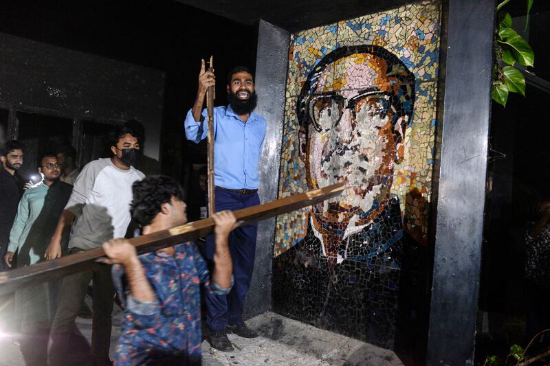 Protesters vandalise a portrait of Sheikh Mujibur Rahman at his residence at Dhanmondi, Dhaka (Mahmud Hossain Opu/AP)