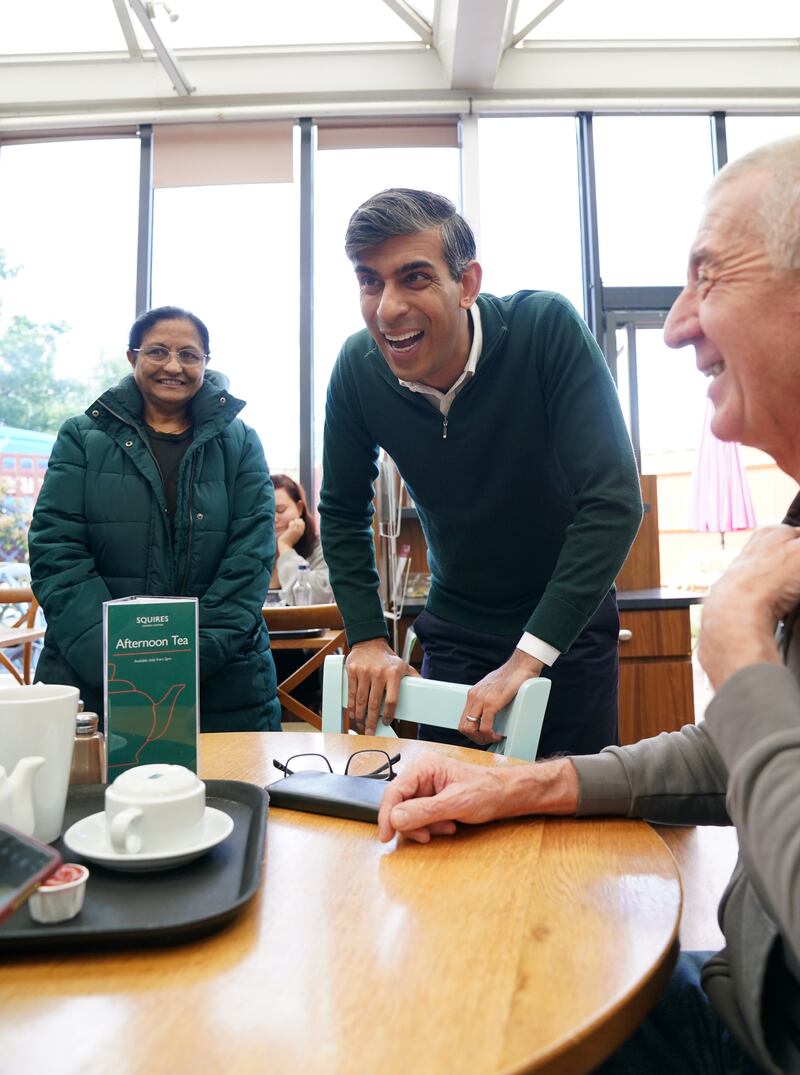 Prime Minister Rishi Sunak talking to locals at a cafe in Squires Garden Centre in Crawley