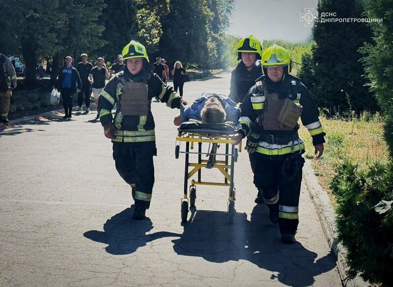 Emergency service workers help a civilian wounded in a Russian missile attack in Pavlohrad, Ukraine, on Friday (Ukrainian Emergency Service via AP)