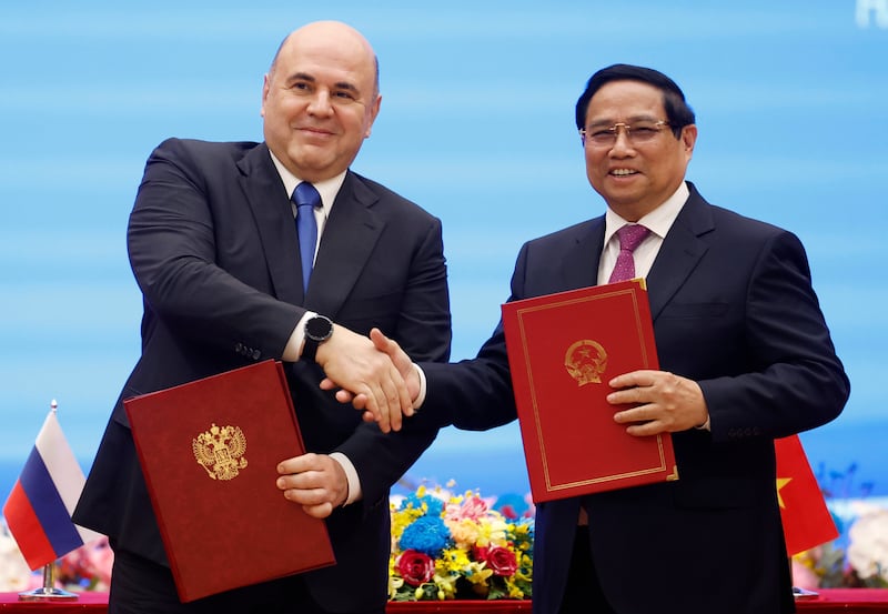 Russian Prime Minister Mikhail Mishustin and Vietnamese premier Pham Minh Chinh shake hands during the signing ceremony in Hanoi (Dmitry Astakhov/Sputnik/Government Pool/AP)