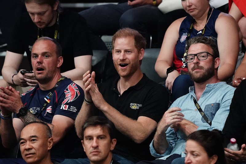 Harry watching the wheelchair basketball at the Invictus Games in Dusseldorf with TV presenter and Invictus medallist JJ Chalmers (right)