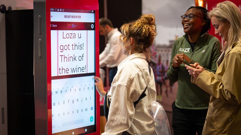 A woman types a Belief Booster encouraging message for a runner in the TCS London Marathon