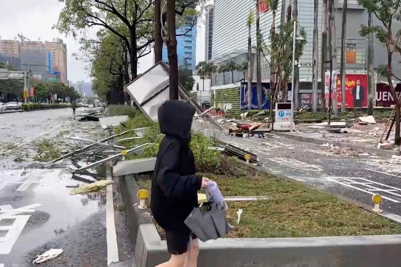 A person walks past debris from an explosion at the Shin Kong Mitsukoshi department store in Taichung city in Taiwan (TVBS via AP )