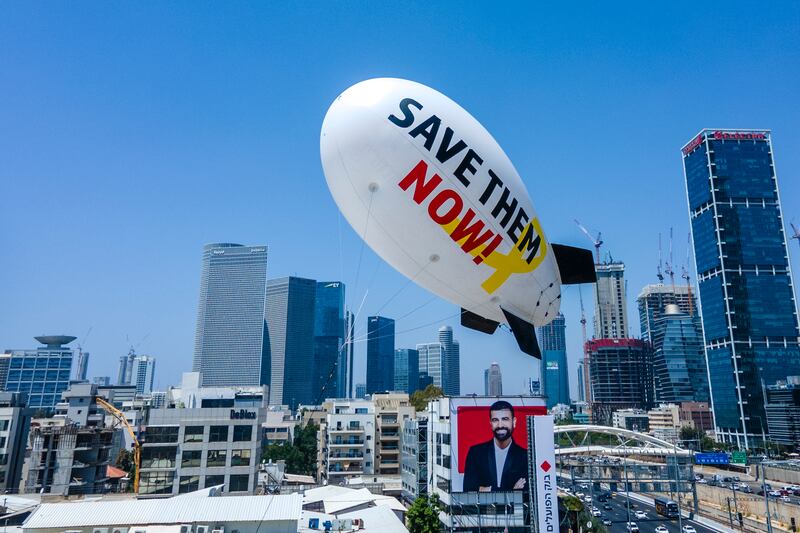 Family and friends of the remaining hostages held in the Gaza Strip by the Hamas militant group launch a small blimp calling for their release in Tel Aviv, Israel (Ariel Schalit/AP)