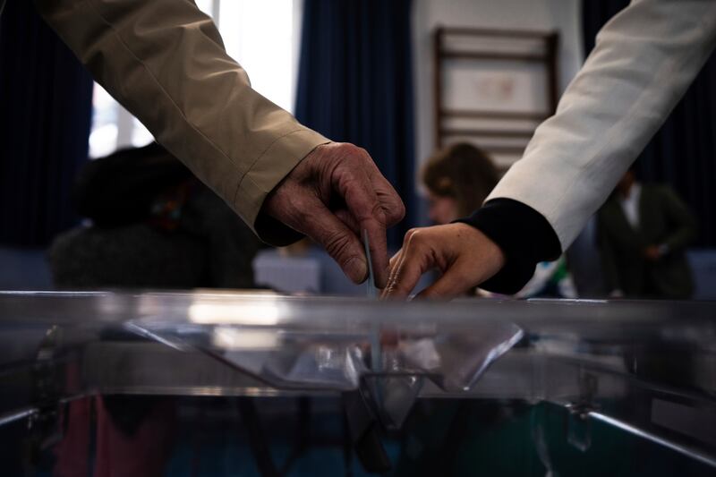 A voter casts his ballot for the second round (Louise Delmotte/AP)