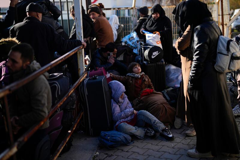 Syrians wait to cross into Syria from Turkey at the Oncupinar border gate, near the town of Kilis, southern Turkey (Khalil Hamra/AP)