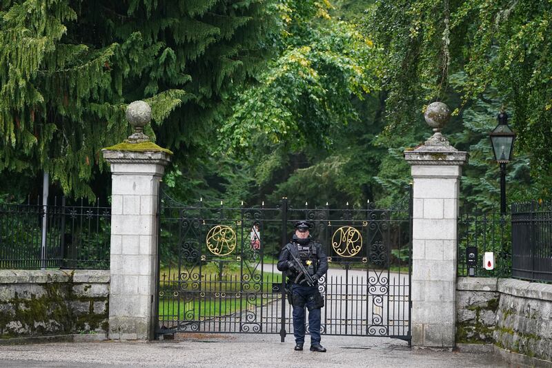 An armed police officer at the gates to Balmoral while the Queen was under medical supervision