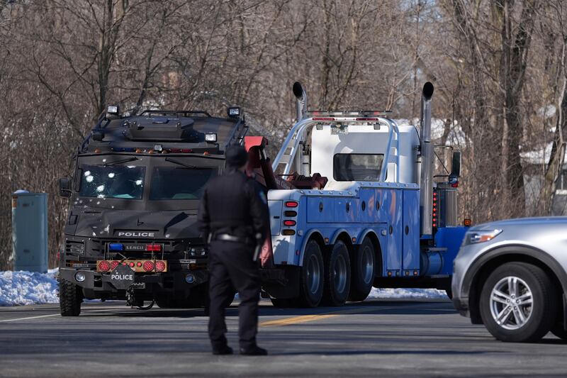 A police vehicle with what appears to be bullet marks is towed away (Abbie Parr/AP)