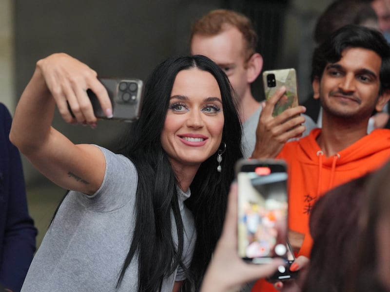 Katy Perry takes a selfie with a fan as she leaves The One Show studio at BBC Broadcasting House in London.