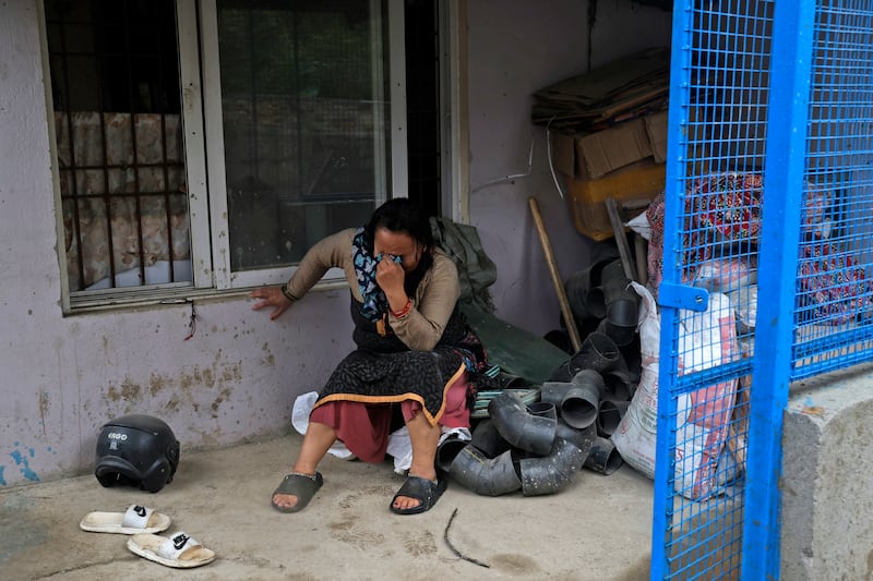 A woman cries after her home was destroyed due to floods caused by heavy rain (Gopen Rai/AP)